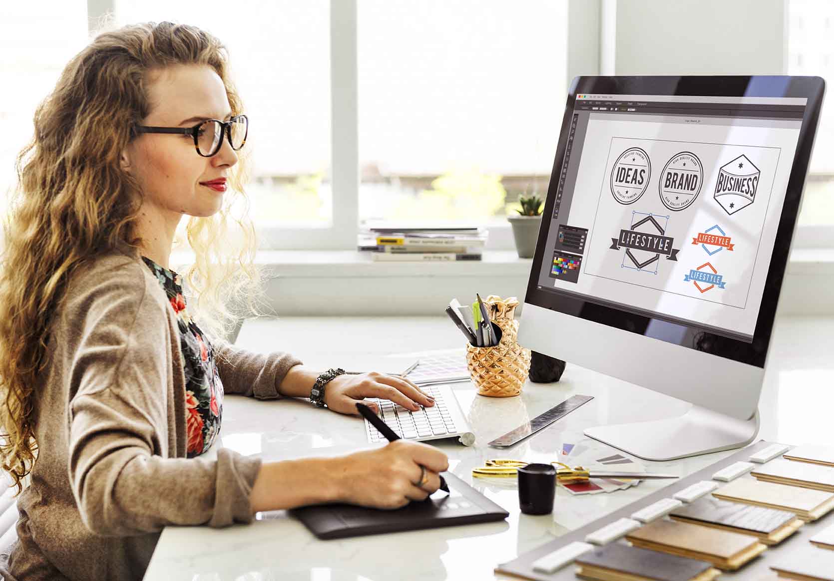 Woman Designer working on different logo concepts using Adobe Photoshop.
